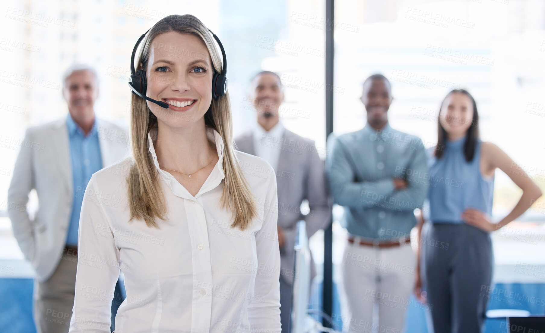 Buy stock photo Portrait of a mature businesswoman using a headset in a modern office with her team in the background