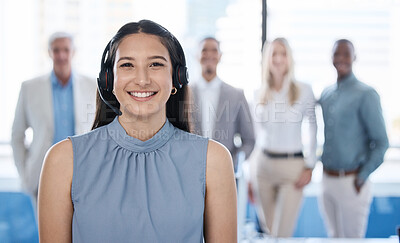 Buy stock photo Portrait of a young businesswoman using a headset in a modern office with her team in the background