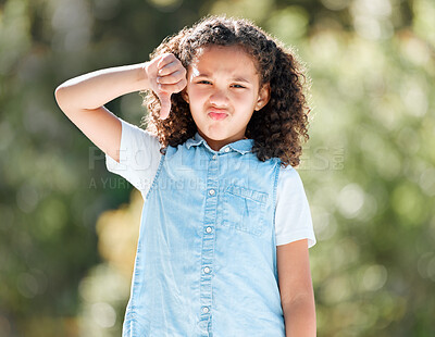 Buy stock photo Shot of a little girl sulking while standing outside