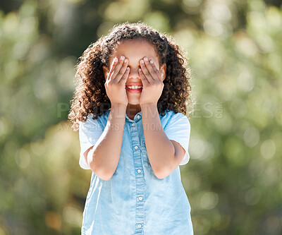 Buy stock photo Shot of an adorable little girl covering her eyes while standing outside