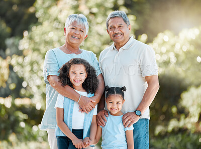 Buy stock photo Shot of a senior couple standing outside with their two granddaughters