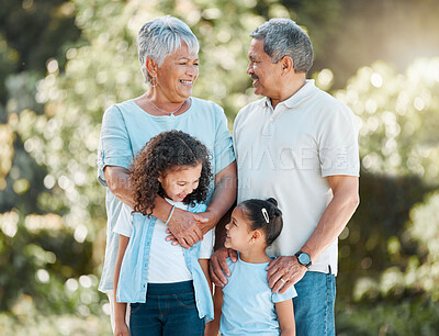 Buy stock photo Shot of a senior couple standing outside with their two granddaughters