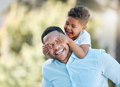Buy stock photo Shot of a little boy covering his father's eyes while playing outside