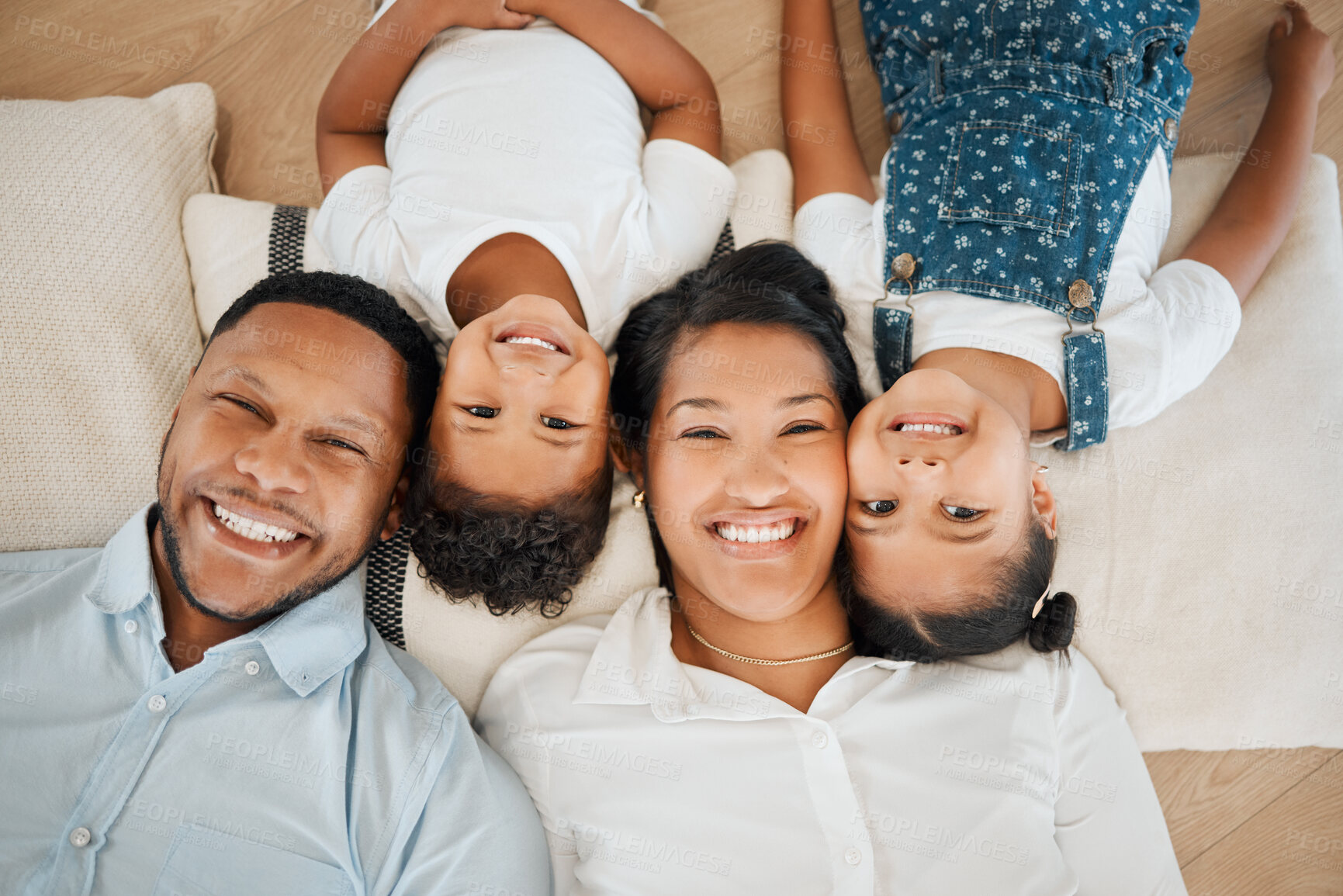 Buy stock photo Portrait, family and smile in home above, bonding and fun on living room floor in house. Parents, African couple and happy children with mother and father for love, relax and together in lounge