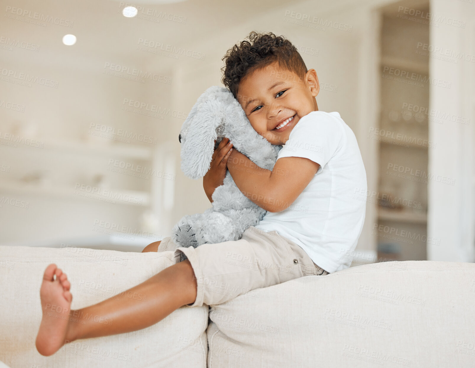 Buy stock photo Portrait, happy child and hug stuffed animal in home for love, care and playing game for development. Smile, boy and embrace toy in living room for support, cute and adorable kid on sofa in Mexico