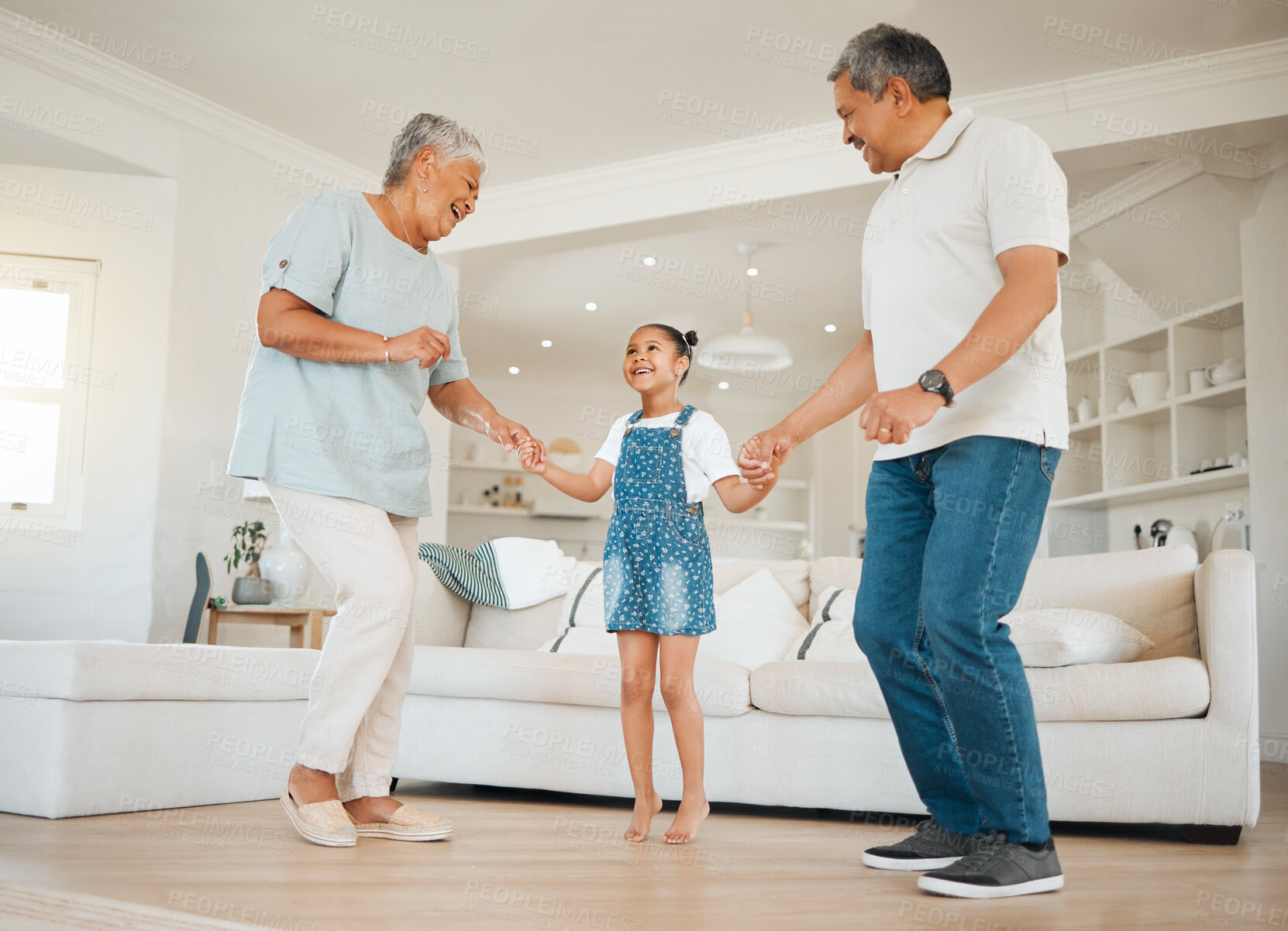 Buy stock photo Dancing, grandparents and child in lounge for connection, bonding together and family for fun in home. Senior people, kid and affection with love, support and happiness for trust, comfort and growth
