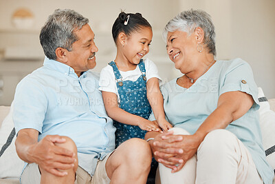 Buy stock photo Shot of grandparents bonding with their granddaughter on a sofa at home