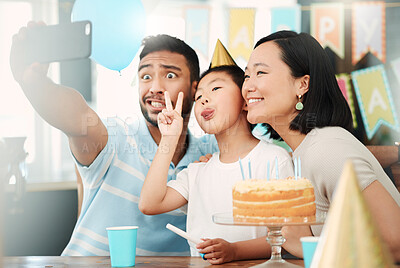 Buy stock photo Shot of a happy family taking selfies while celebrating a birthday at home