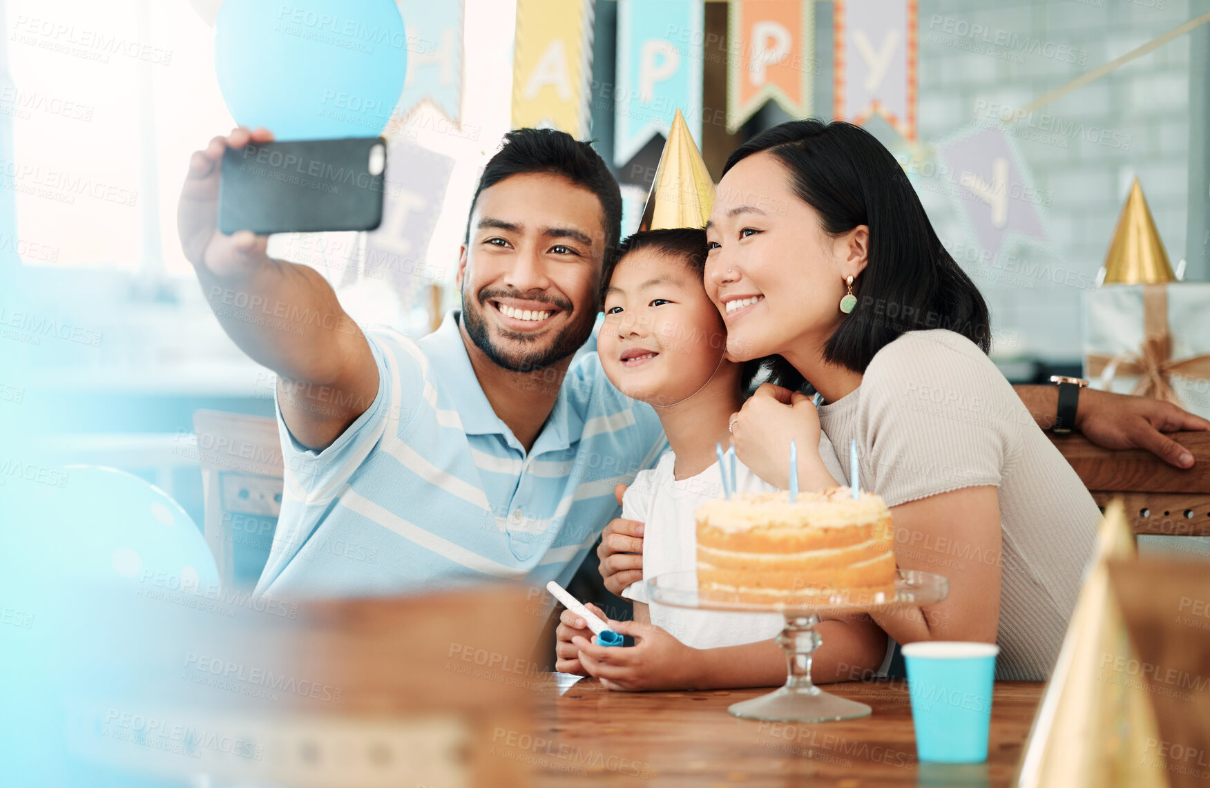 Buy stock photo Shot of a happy family taking selfies while celebrating a birthday at home