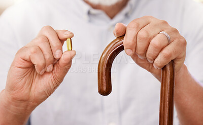 Buy stock photo Cropped shot of a senior man sitting at home with a wooden walking stick