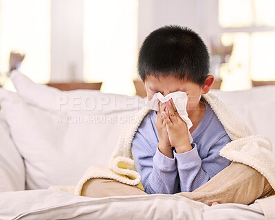Buy stock photo Shot of a little boy feeling sick while sitting at home