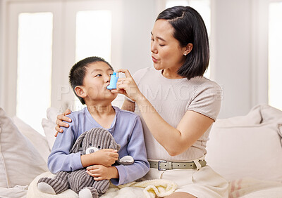 Buy stock photo Shot of a woman helping her son with his asthma inhaler