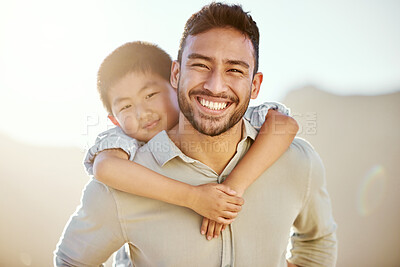 Buy stock photo Cropped portrait of a handsome young man piggybacking his son on the beach