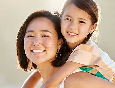 Buy stock photo Cropped portrait of an attractive young woman piggybacking her daughter on the beach