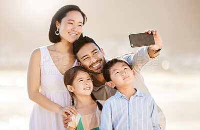 Buy stock photo Cropped shot of a happy diverse family of four taking selfies at the beach