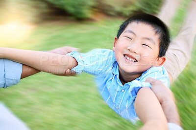 Buy stock photo Shot of a little boy being swung by his parent in their garden at home