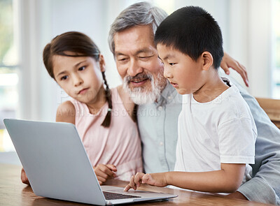 Buy stock photo Shot of a grandfather helping his grandchildren with their homework at home