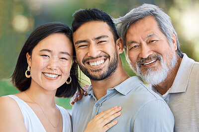 Buy stock photo Shot of a happy young man and woman spending time with their elderly father in a garden