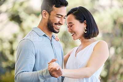 Buy stock photo Shot of a happy young couple dancing in a garden