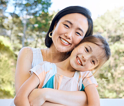 Buy stock photo Shot of an adorable little girl and her mother embracing in a garden