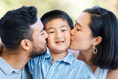 Buy stock photo Shot of an adorable little boy being kissed by his parents in a garden