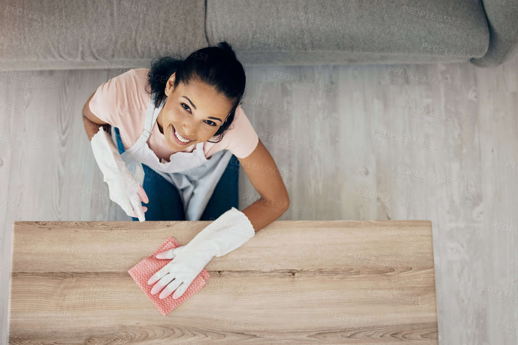 Buy stock photo Cleaning, table and portrait of a woman in a house to clean with supplies, chemical and cloth. Above young female or cleaner in a lounge, apartment or room with a smile to polish wood or wipe dirt