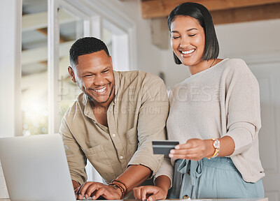 Buy stock photo Shot of a young couple using a laptop and credit card at home