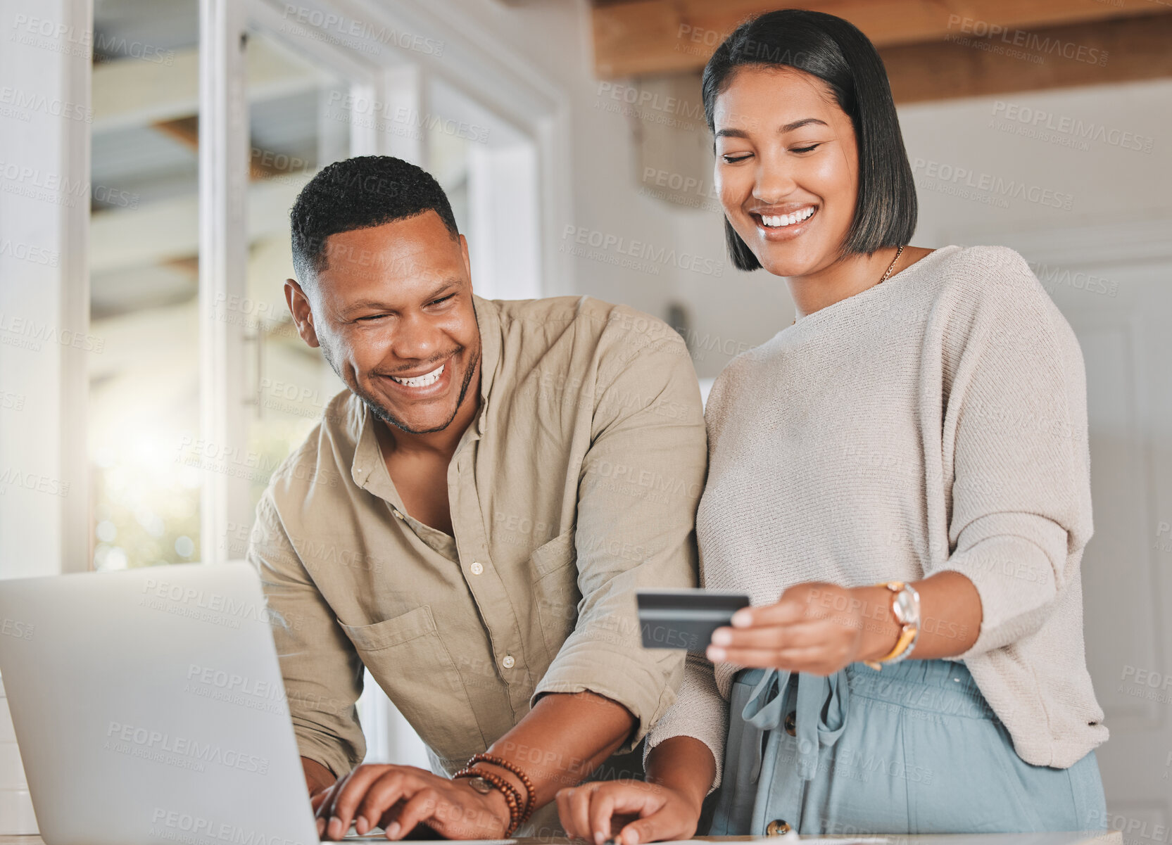 Buy stock photo Shot of a young couple using a laptop and credit card at home