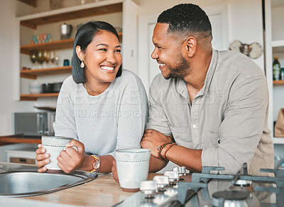 Buy stock photo Shot of a young couple drinking coffee together in the kitchen at home