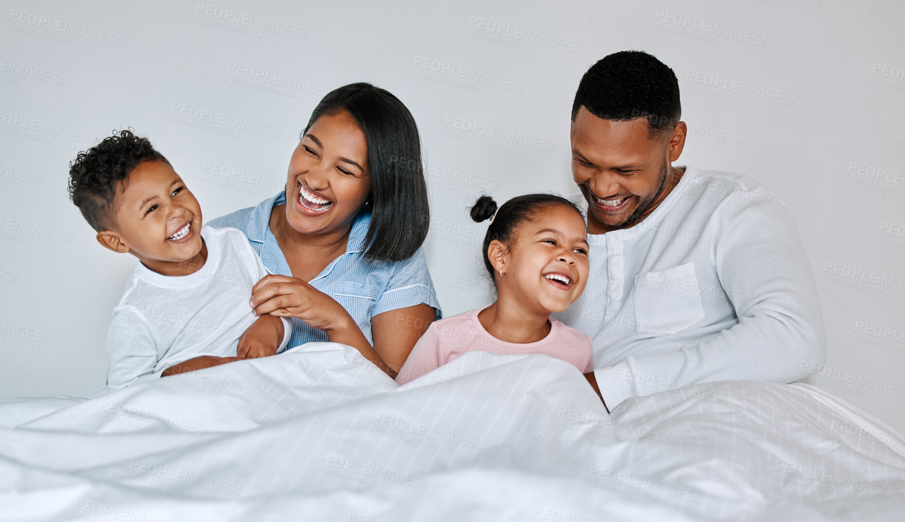 Buy stock photo Shot of a young family relaxing at home