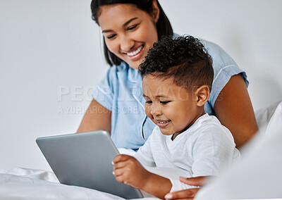 Buy stock photo Shot of a little boy and his mother using a digital tablet at home