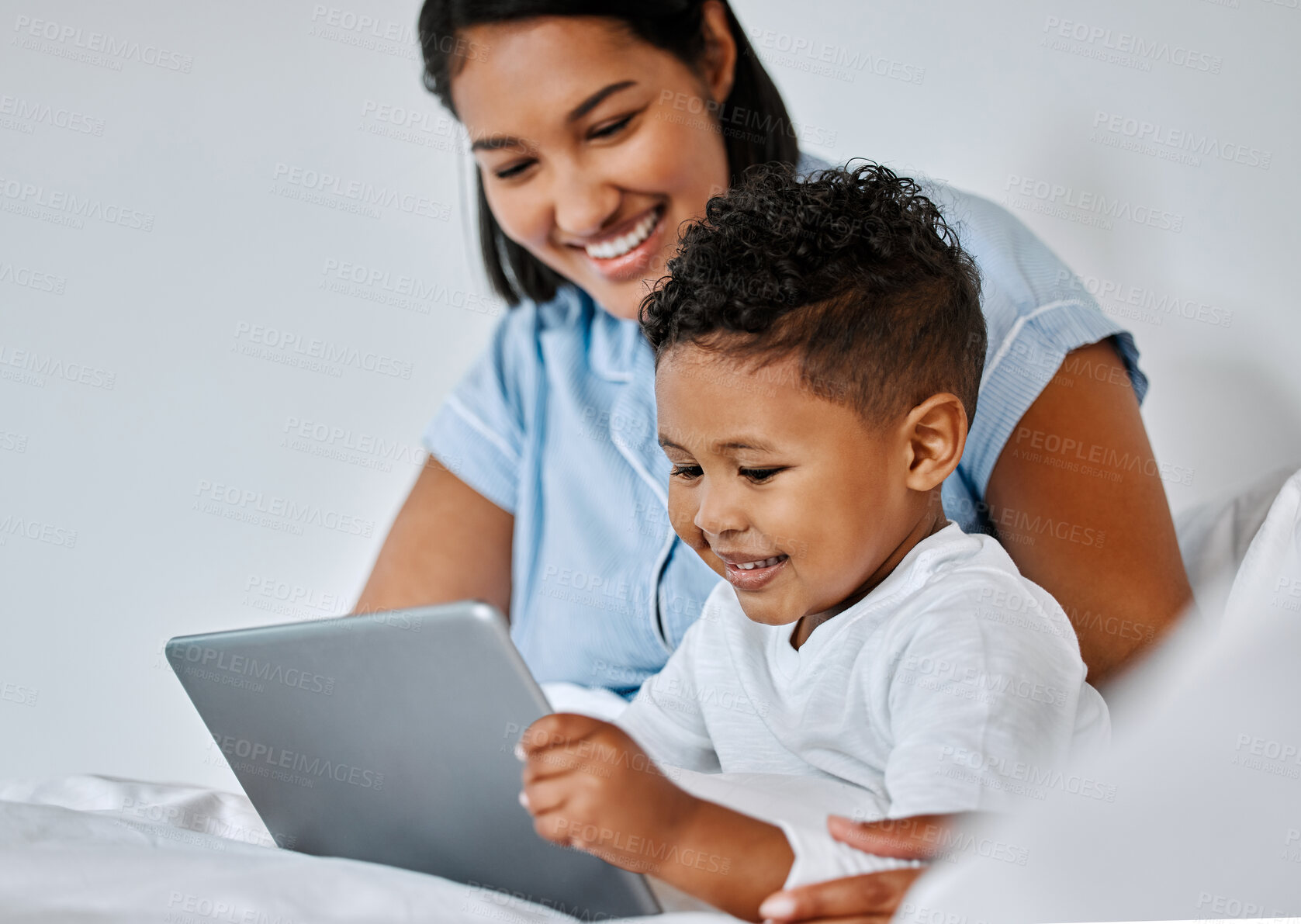 Buy stock photo Shot of a little boy and his mother using a digital tablet at home