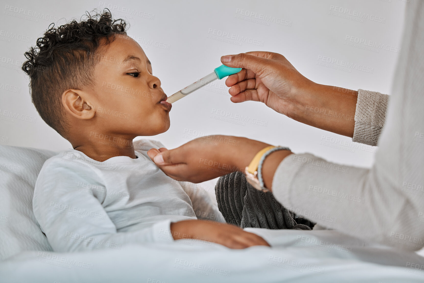 Buy stock photo Shot of a sick little boy drinking medicine at home