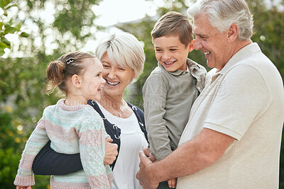 Buy stock photo Shot of a senior couple spending time outdoors with their two grandchildren