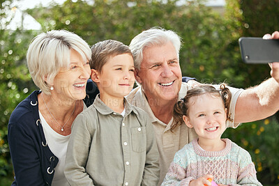 Buy stock photo Shot of a senior couple taking a selfie with their two grandchildren
