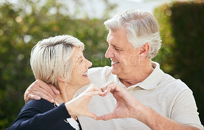 Buy stock photo Shot of a senior couple forming a heart shape with their hands