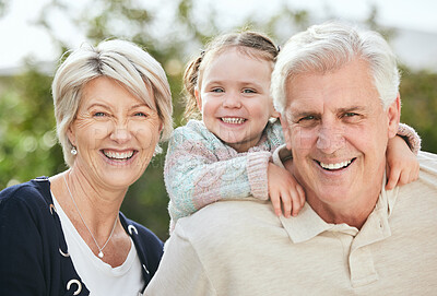 Buy stock photo Shot of a senior couple spending time outdoors with their granddaughter