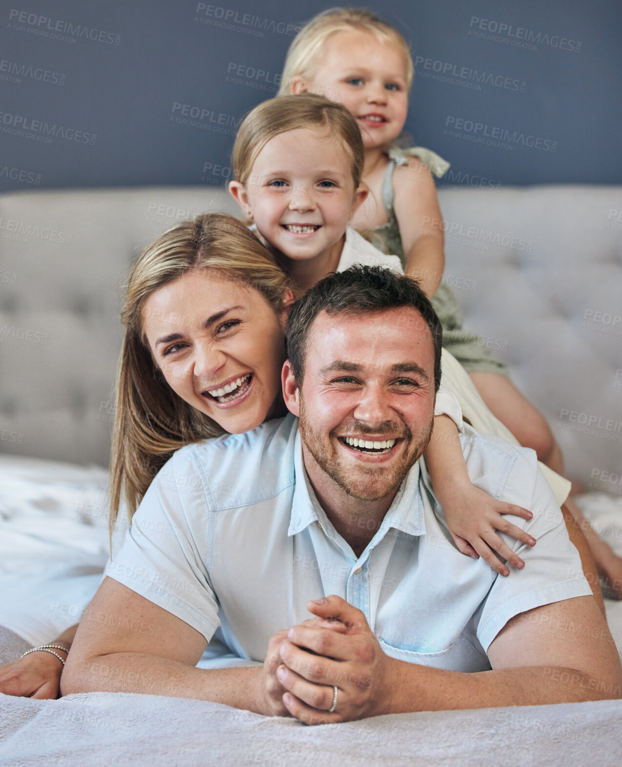 Buy stock photo Happy, relax and children with parents on bed for bonding, playing and having fun together. Portrait, home and girl kids laying on mother and father for resting in bedroom at house in London.