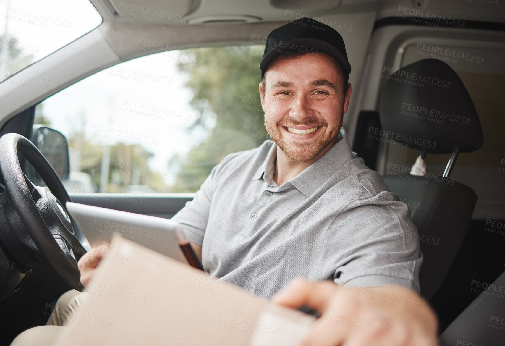 Buy stock photo Cropped portrait of a handsome young delivery man using a tablet while sitting in his van