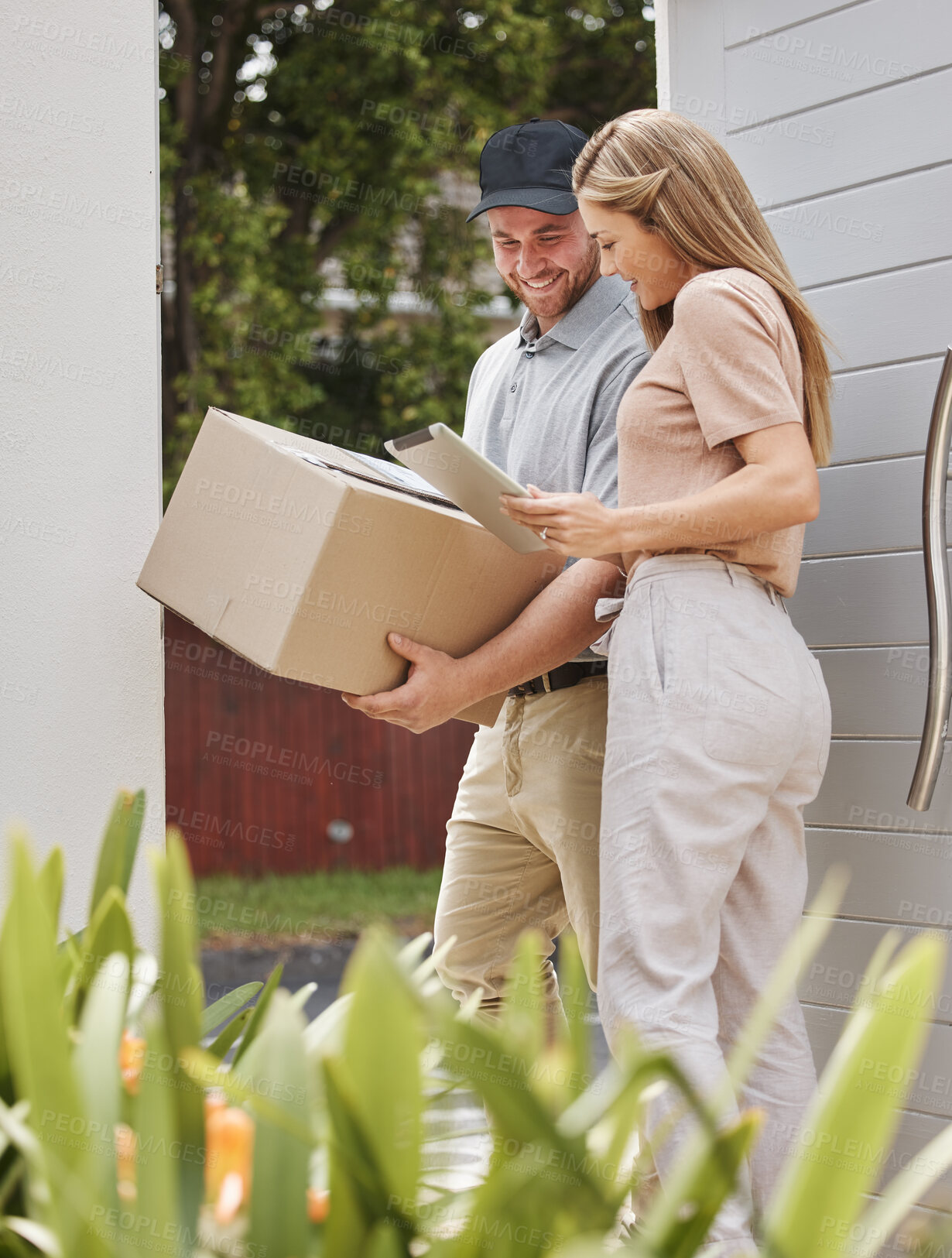 Buy stock photo Cropped shot of an attractive young woman using a tablet to sign for her delivery