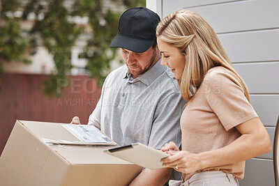 Buy stock photo Cropped shot of an attractive young woman using a tablet to sign for her delivery