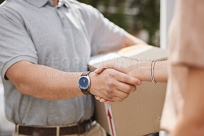 Buy stock photo Cropped shot of an unrecognizable male courier shaking hands with a female customer during his delivery