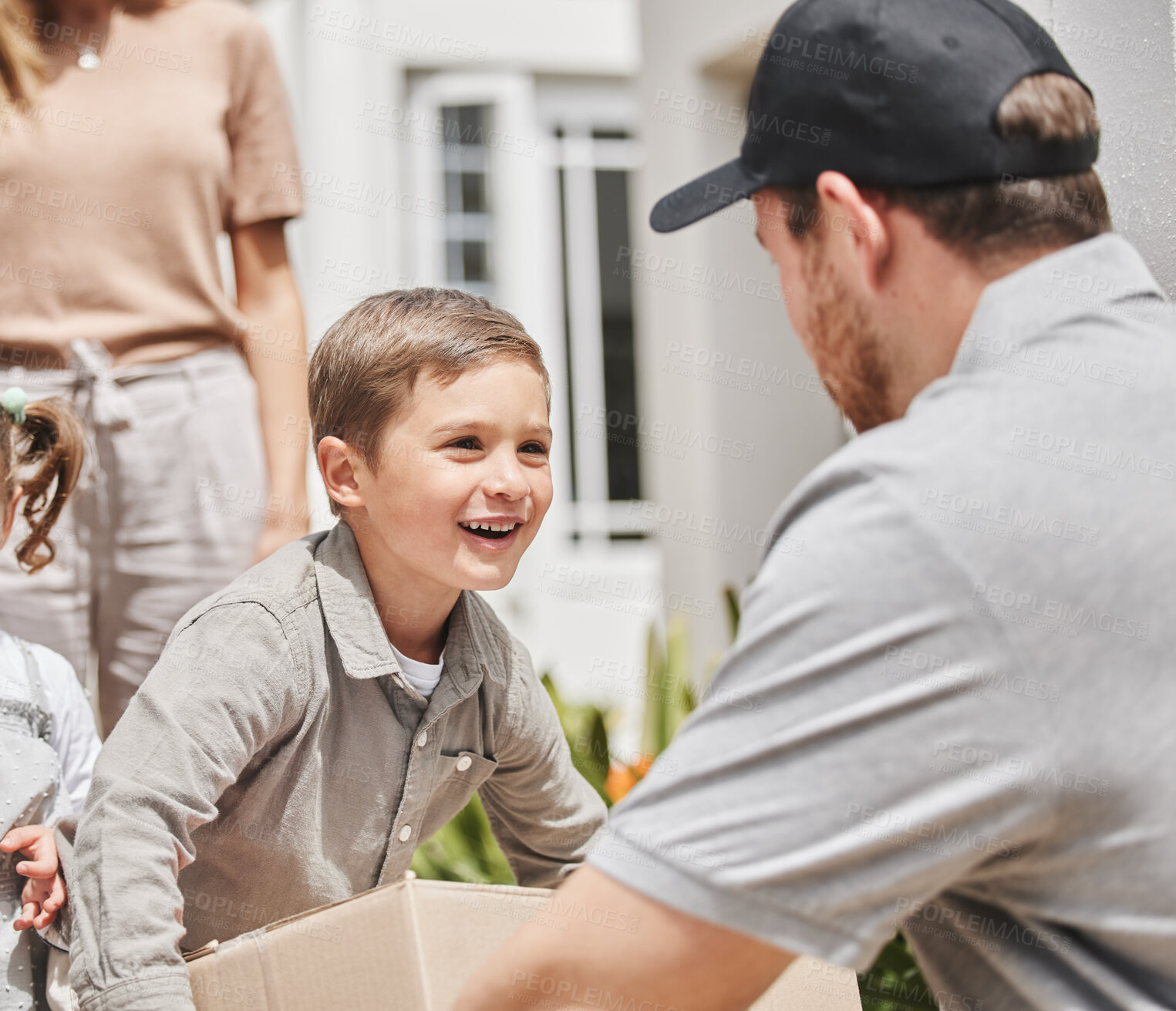 Buy stock photo Cropped shot of an adorable little boy collecting his mother's delivery from a male courier