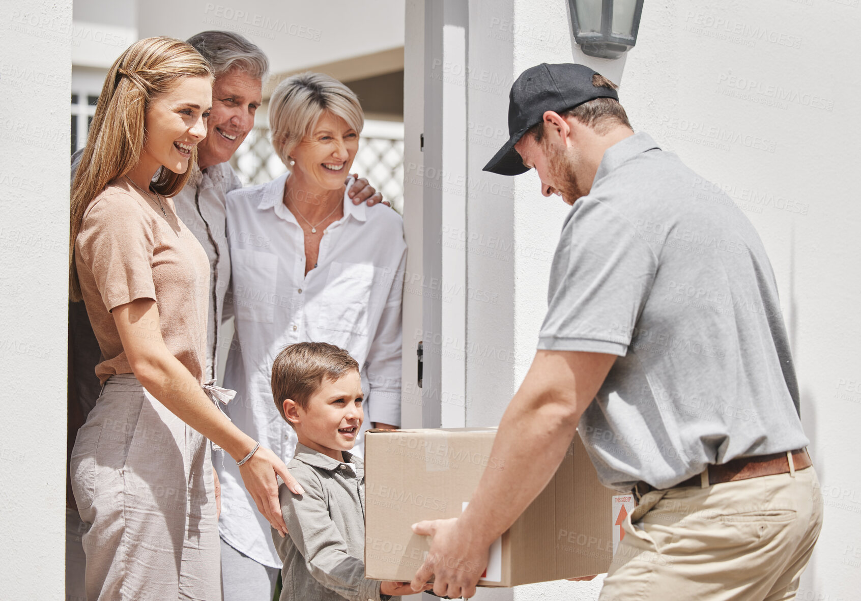 Buy stock photo Cropped shot of an adorable little boy collecting his family's delivery from a male courier