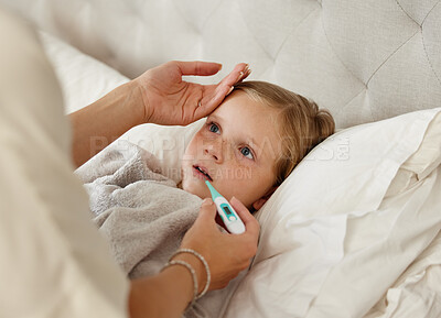 Buy stock photo Shot of a woman taking her little girls temperature with a thermometer in bed at home