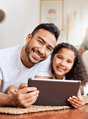 Buy stock photo Shot of a young father and daughter using a digital tablet together at home