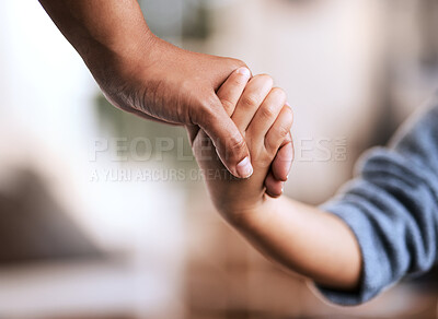 Buy stock photo Shot of an unrecognizable parent and child holding hands at home