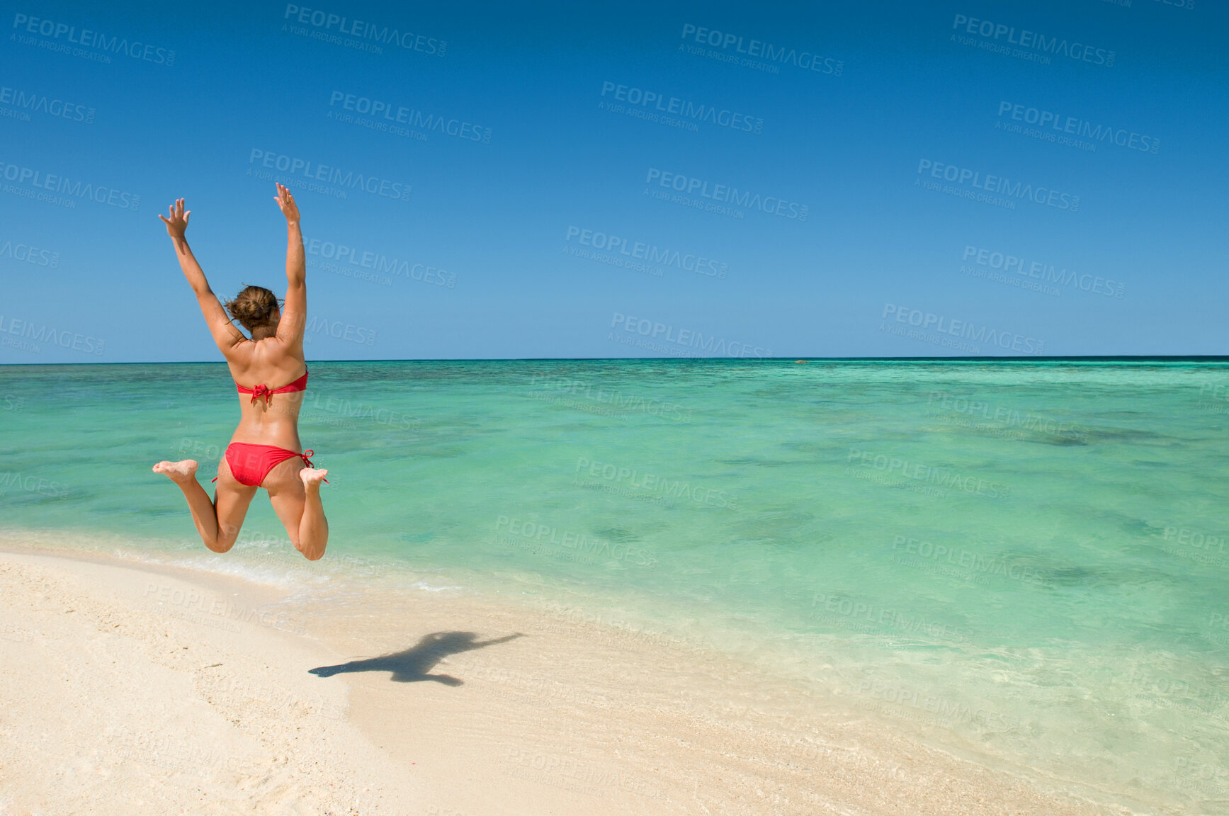 Buy stock photo Woman, back and jump for freedom on beach, happiness outdoor and excited for holiday, travel and ocean. Bikini, sun and sand with summer fun, energy and care free in nature with horizon in Thailand