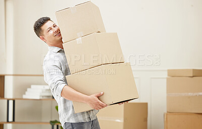 Buy stock photo Shot of a handsome young man carrying boxes into his new home