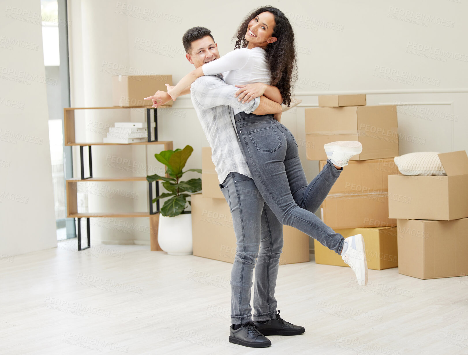 Buy stock photo Moving, hugging and portrait of couple in new home in celebration for mortgage or property investment. Happy, love and man lifting woman for embracing at rental apartment with cardboard package.